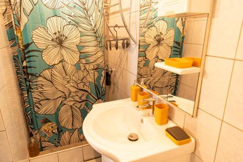 a bathroom with a sink and a shower curtain at Bel La Vi Apartment in Le Lamentin