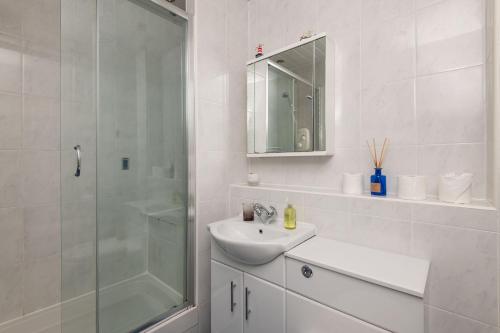 a white bathroom with a sink and a shower at The Crow's Nest - Elie in Elie
