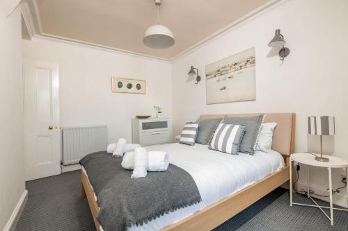a bedroom with a bed with white sheets and pillows at The Crow's Nest - Elie in Elie