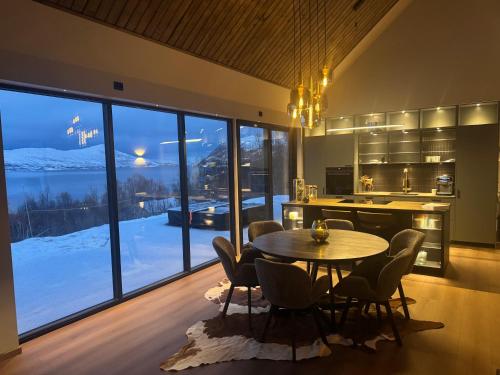 een keuken met een tafel en stoelen en een groot raam bij LyNora Lodge 