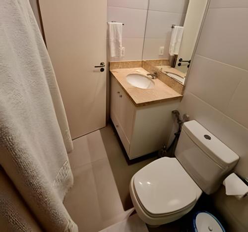 a small bathroom with a toilet and a sink at Gramado Loft 105 in Gramado