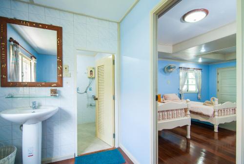 a bathroom with a sink and a shower at Tum Baan Suan ตุ่มบ้านสวน in Chanthaburi