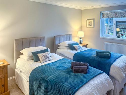1 Schlafzimmer mit 2 Betten mit blauen und weißen Decken in der Unterkunft 2 Bed in Gimingham oc-h27869 in Trimingham
