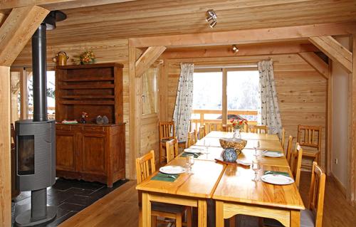 - une salle à manger avec une table en bois dans une cabine dans l'établissement Odalys Chalet La Muzelle, à Les Deux Alpes