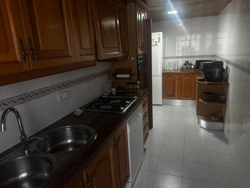 滨海托萨Thelma house Tossa的厨房里有水槽和炉灶。 上层烤箱