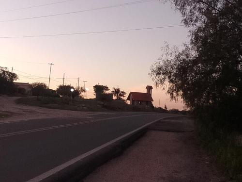 eine leere Straße mit einem Haus am Straßenrand in der Unterkunft Los patos in Capilla del Monte