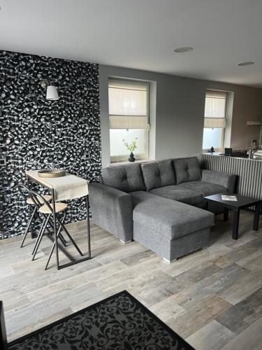 een woonkamer met een bank en een tafel bij Le refuge de Villeroux in Vaux-sur-Sûre