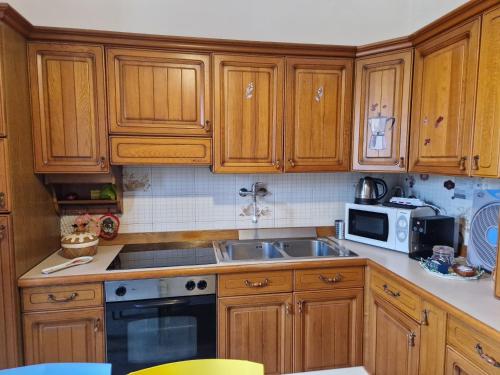 een keuken met houten kasten en een spoelbak bij Villa Teresa in Giovinazzo