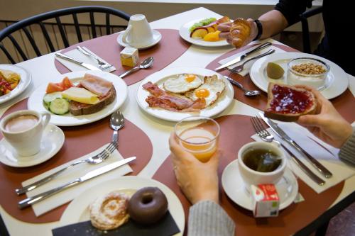 uma mesa com pratos de café da manhã sobre ela em Hotel Oros by Nexta em Encamp