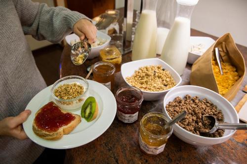 uma pessoa que segura um prato de comida numa mesa em Hotel Oros by Nexta em Encamp