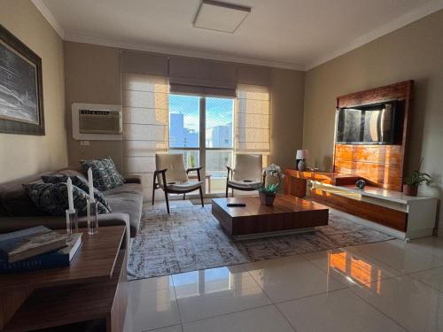 un salon avec un canapé et une table dans l'établissement Linda Cobertura Pitangueiras, à Guarujá