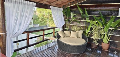 un balcone con una vasca da bagno con piante sopra di Chalé Valen a Rio de Janeiro