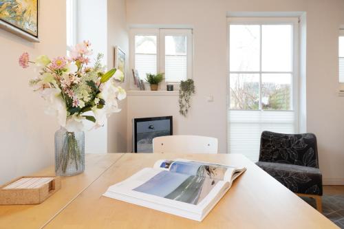 una stanza con un tavolo con un vaso di fiori di Räucherhäuschen a Fehmarn