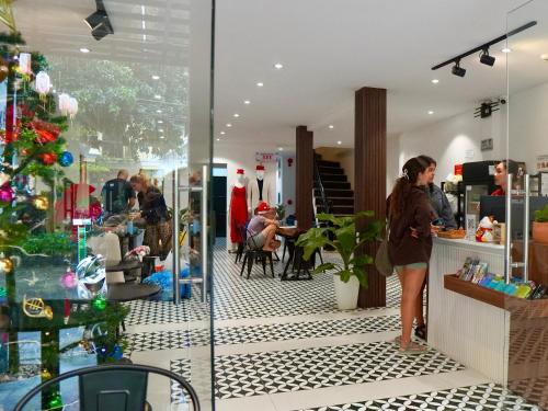 HY Local Budget Hotel - 5 mins walk to Hoi An Ancient Town في هوي ان: امرأة تقف أمام متجر