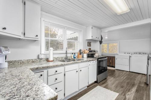 a kitchen with white cabinets and white appliances at Cozy 3BD with Air Hockey, BBQ - Near Duke University in Durham
