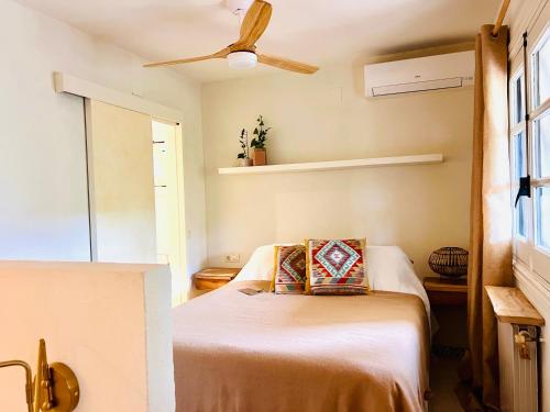 een slaapkamer met een bed en een plafondventilator bij Back to La Tierra, natural finca in Mijas in Mijas