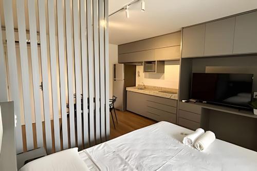 una camera da letto con un letto bianco e una cucina di Unique a Viçosa