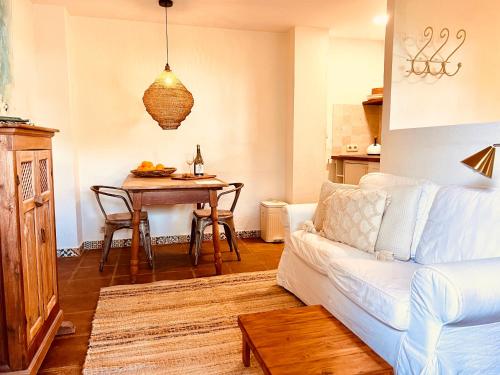 een woonkamer met een witte bank en een tafel bij Back to La Tierra, natural finca in Mijas in Mijas