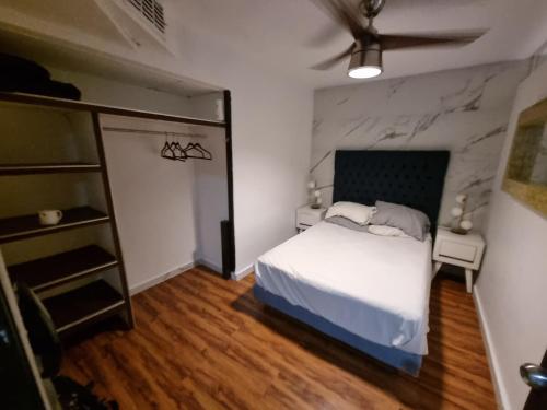 a bedroom with a white bed and a stone wall at La mejor ubicación Condomar 133 in Puerto Vallarta