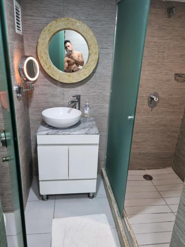 a man taking a picture in a bathroom mirror at La mejor ubicación Condomar 133 in Puerto Vallarta