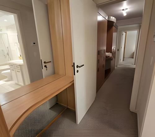 un corridoio di un bagno con lavandino e specchio di Residencial Seidl Gramado a Gramado