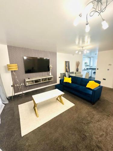 een woonkamer met een blauwe bank en een tv bij The Pheasant - Luxury 3-bedroom Apartment in Dartford in Dartford