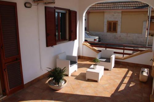 een patio met 2 stoelen en een tafel en een gebouw bij Villetta AmaMare in Torre Lapillo