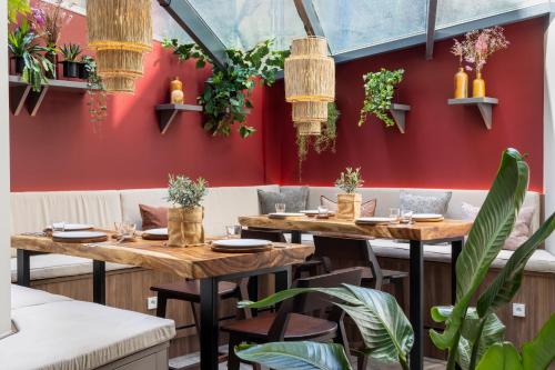 een restaurant met houten tafels, stoelen en planten bij Ikonik Jean Médecin in Nice