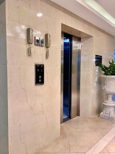a elevator in a lobby with a vase on the wall at City Garden Olympus condo balcony in Pattaya South