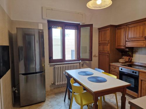 een keuken met een tafel met stoelen en een koelkast bij Villa Teresa in Giovinazzo
