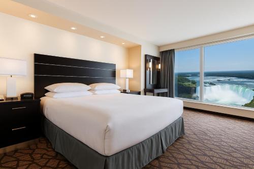 een grote slaapkamer met een groot bed en een groot raam bij Tower Hotel at Fallsview in Niagara Falls