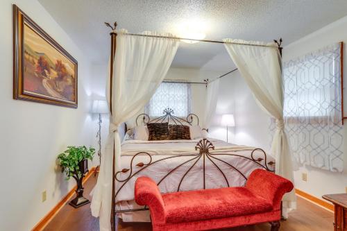 ein Schlafzimmer mit einem Himmelbett und einem roten Stuhl in der Unterkunft 1 Mi to Dtwn Mountain View Home with Deck in Mountain View
