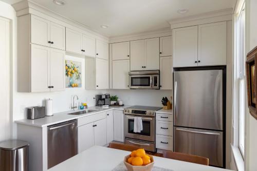 eine Küche mit weißen Schränken und Geräten aus Edelstahl in der Unterkunft 2 King Bedrooms Luxury On Historic Crawford Square in Savannah