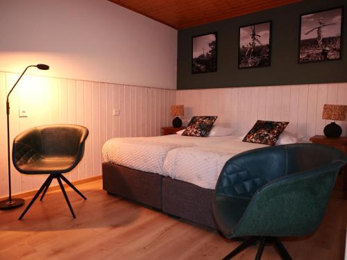 een slaapkamer met een bed en een stoel bij Landhaus Meine Auszeit in Bodenmais