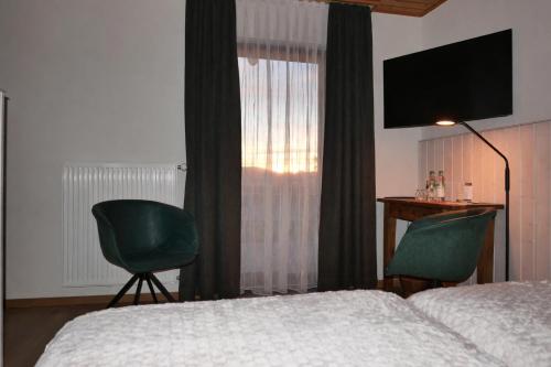 een slaapkamer met een bed, een bureau en een televisie bij Landhaus Meine Auszeit in Bodenmais