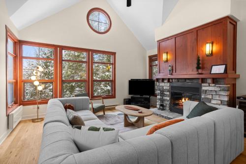 a living room with a couch and a fireplace at Les Eaux 3BR, Sauna, Fireplace and Jacuzzi Access in Mont-Tremblant