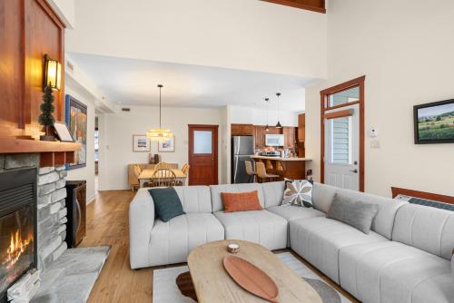 a living room with a white couch and a fireplace at Les Eaux 3BR, Sauna, Fireplace and Jacuzzi Access in Mont-Tremblant