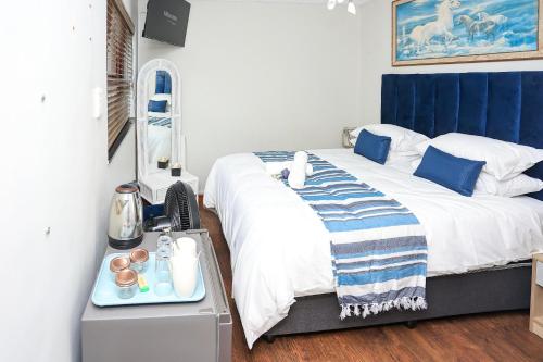 a bedroom with a large bed with a blue headboard at African Oasis Cameroon in Somerset West