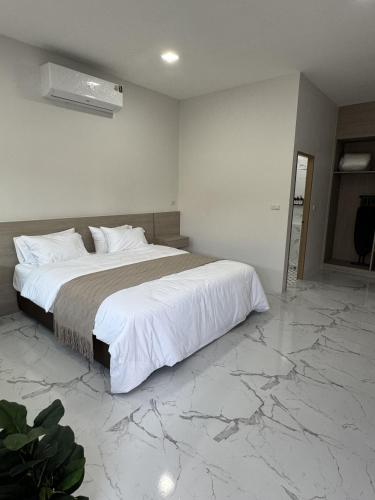 a bedroom with a large bed with marble floors at Tanya's Cafe & Resort in Ban Kasang