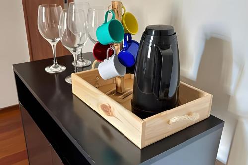 Eine Flasche Wein auf einem Holztablett mit Weingläsern in der Unterkunft Village in Viçosa