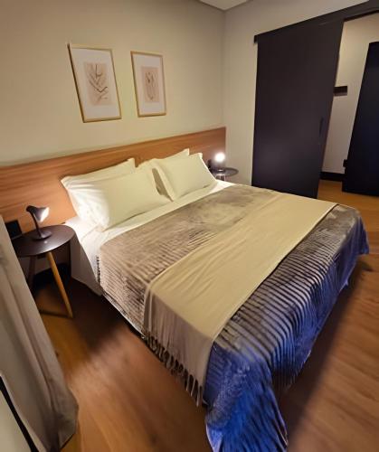 a bedroom with a large bed with white pillows at Tribeca Gramado 12 in Gramado