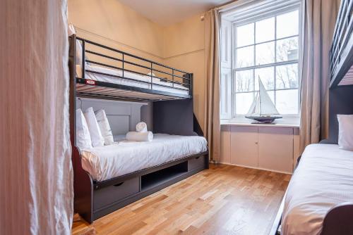 a bedroom with a bunk bed and a sailboat in a window at The Winkle - Elie in Elie