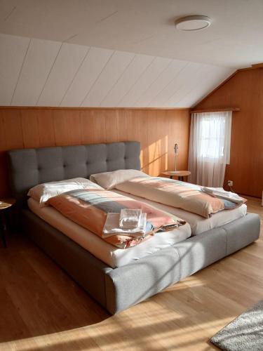 a large bed in a room with wooden walls at Hostel Engelberg "mein Trail Hostel" in Engelberg