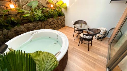 een bad in een kamer met een plant bij W Tambaú Apart Hotel in João Pessoa