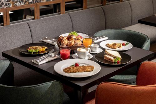 a table with plates of food and pastries on it at Radisson Blu Hotel, Florence in Florence