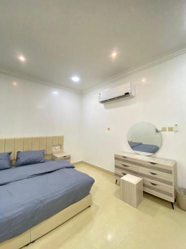 una camera da letto con un letto, uno specchio e una cassettiera di شقق vip a Al Hofuf