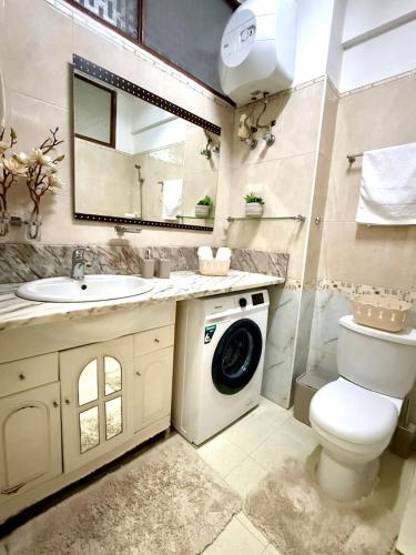 een badkamer met een wasmachine en een wastafel bij Maianga Flat in Luanda