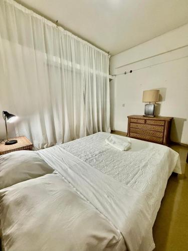 een slaapkamer met een wit bed en een raam bij Maianga Flat in Luanda