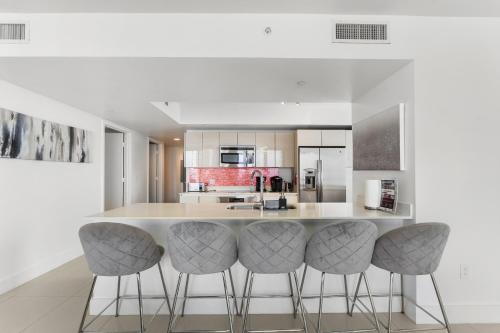 a kitchen with a large island with bar stools at Spacious Luxury Apartment at Beachwalk Resort with Ocean Views and Private Foyer in Hallandale Beach