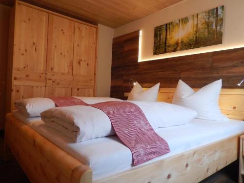 een slaapkamer met een bed met witte kussens bij Ferienwohnung Hirtreiter in Lalling